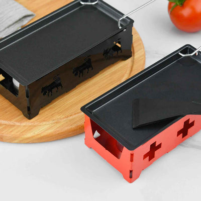 appareil a raclette rouge et noir sur table